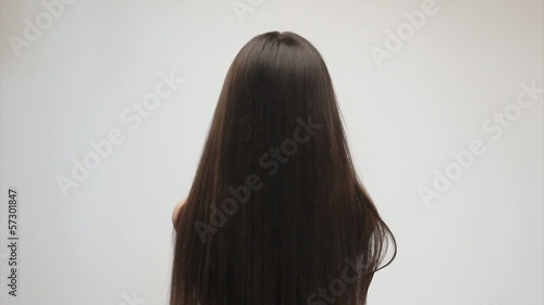 Young woman gently touching her long hair photo