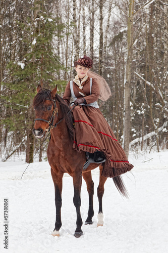 Woman in the brown riding habit keeps Arab racer