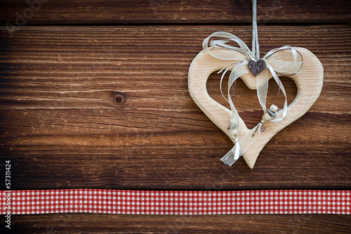 clipped wooden heart hanging on sun burned wood planks