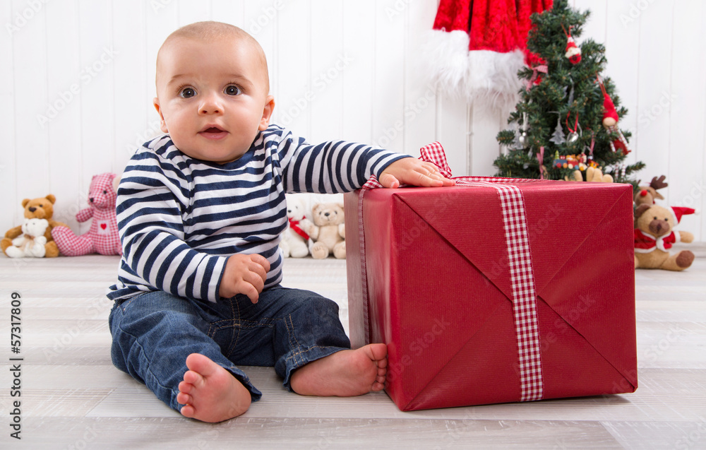 Baby mit einem Geschenk zu Weihnachten in Rot Baby mit einem Geschenk zu Weihnachten in Rot