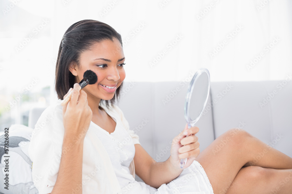 Lovely young dark haired woman in white clothes applying powder Lovely young dark haired woman in white clothes applying powder