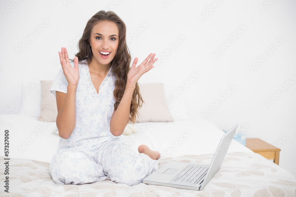 Surprised attractive brunette sitting next to a laptop Surprised attractive brunette sitting next to a laptop