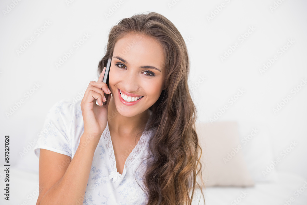 Cheerful pretty brunette holding mobile phone Cheerful pretty brunette holding mobile phone