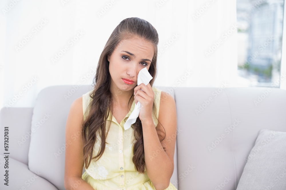 Upset young brunette holding a tissue Upset young brunette holding a tissue