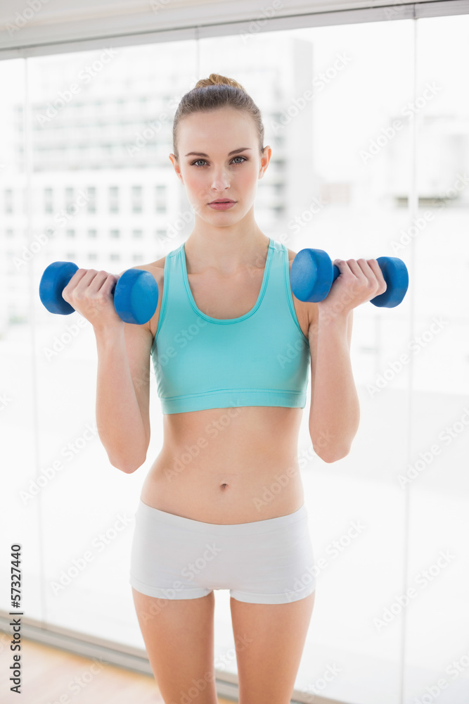 Sporty serious woman holding dumbbells Sporty serious woman holding dumbbells