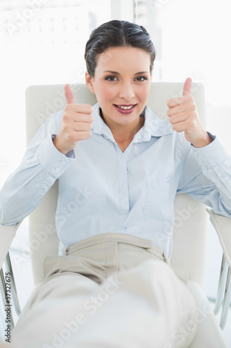 Content stylish brunette businesswoman giving thumbs up