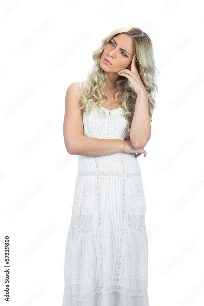 Thoughtful attractive model in white dress posing touching her h