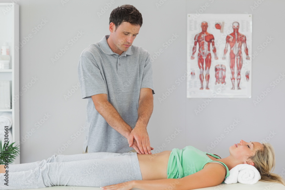 Fototapeta premium Physiotherapist examining patients pelvis