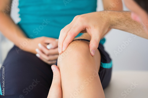 Physiotherapist controlling patients knee