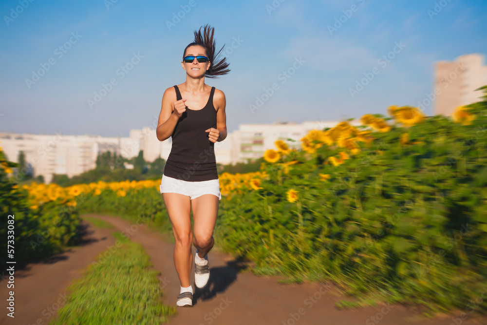 athlete on morning jog in the sunflower's field