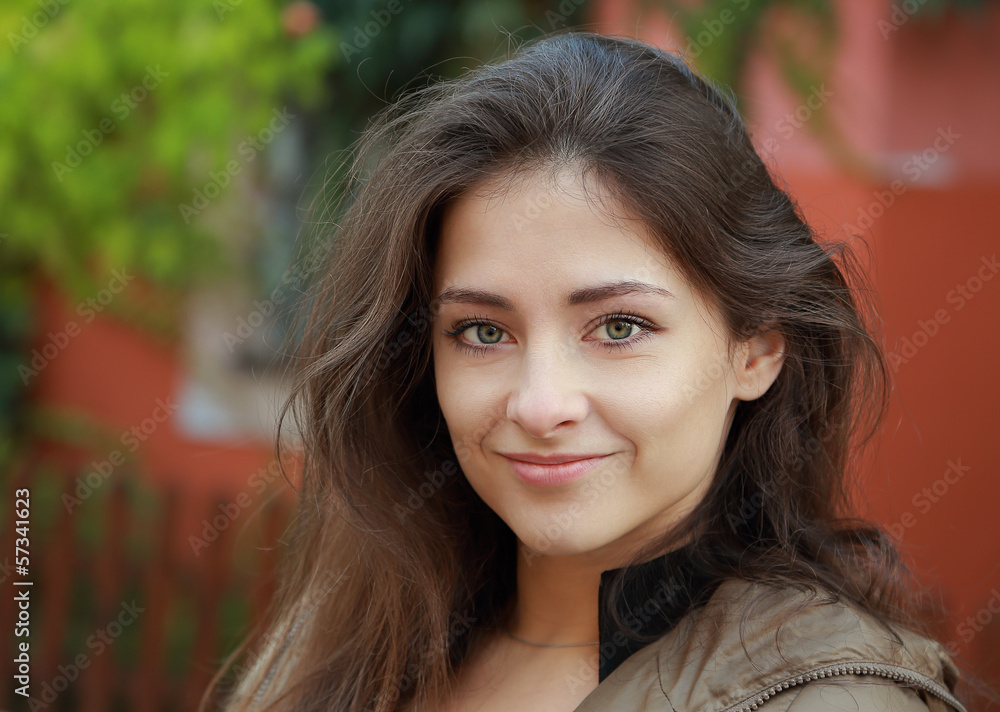 Fototapeta premium Cute woman with green eyes looking happy outdoors background