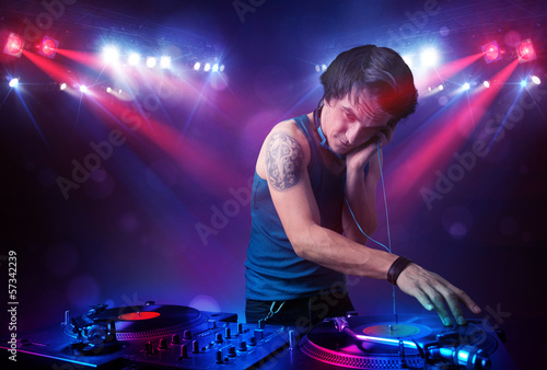 Teenager dj mixing records in front of a crowd on stage