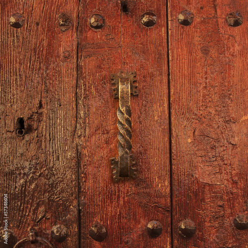 Varnished wooden door with antique doorhandle