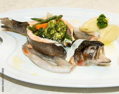 Steamed  trout with vegetables on white dish