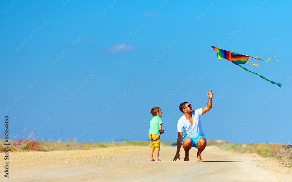 Fototapeta premium father and son having fun, playing with kite together