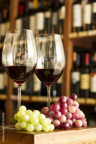 Copas de Vino tinto, botellas y uvas. Vineria vinoteca. photo