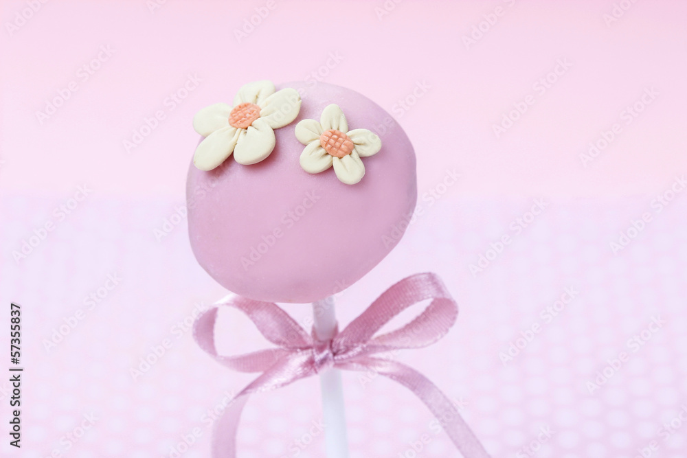 Pink cake pops decorated with colorful sprinkles.