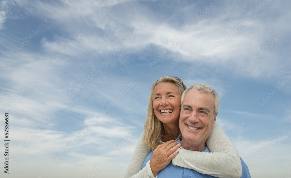 Senior Man Piggybacking Woman Against Cloudy Sky Senior Man Piggybacking Woman Against Cloudy Sky