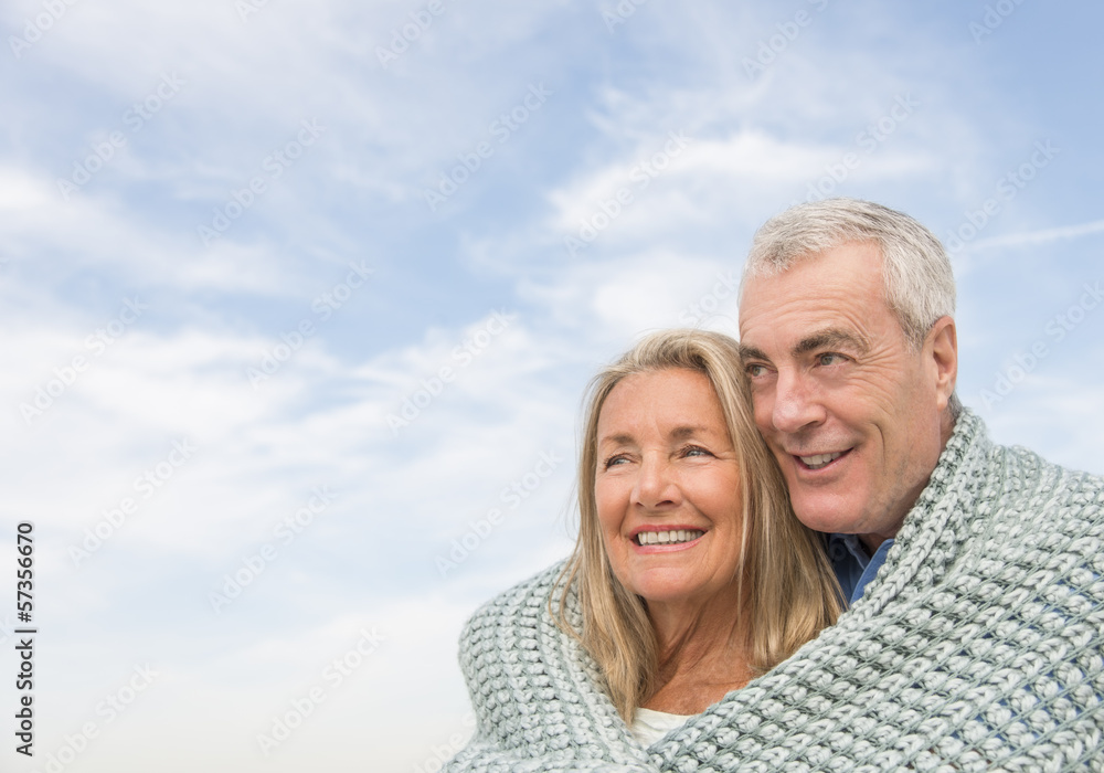 Couple Wrapped In Blanket Looking Away Against Sky Couple Wrapped In Blanket Looking Away Against Sky