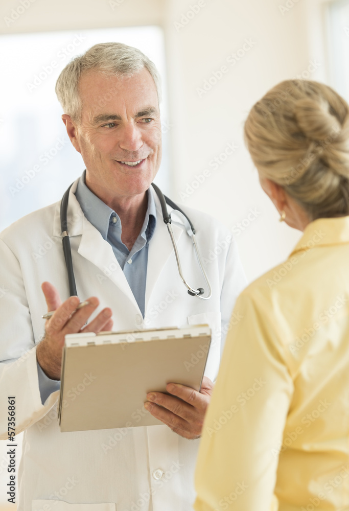 Doctor Explaining Report To Patient At Clinic Doctor Explaining Report To Patient At Clinic