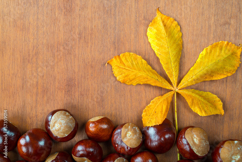chestnuts with leaf on wooden board