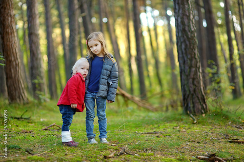 Two little sisters hiking in a forest