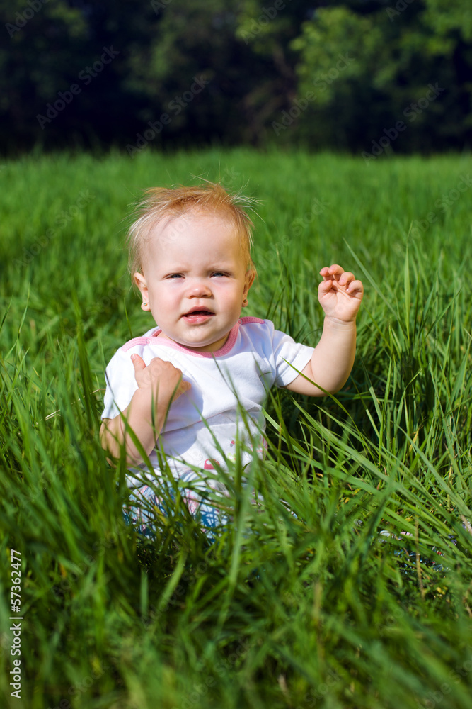 Little girl sitting on a green grass Little girl sitting on a green grass