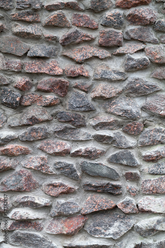 Old gray rough stone wall. Vertical background photo texture