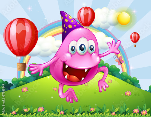 A happy pink beanie monster jumping at the hilltop