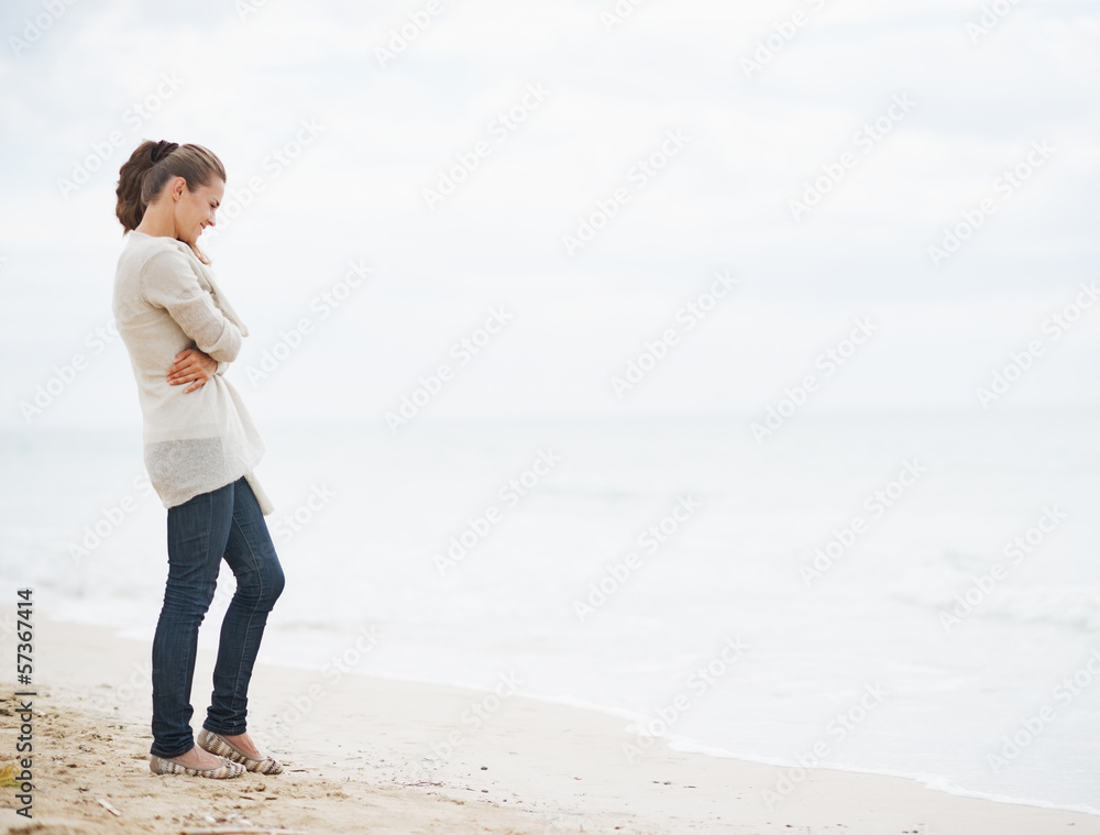 Full length portrait of young woman in sweater on beach Full length portrait of young woman in sweater on beach