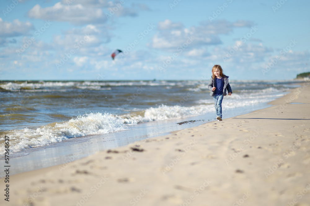 Adorable little girl playing on the beach