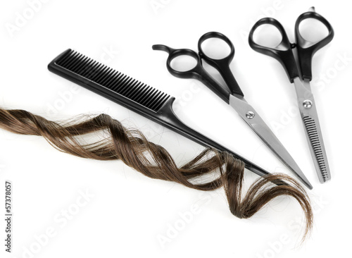 Shiny brown curl with scissors and comb isolated on white