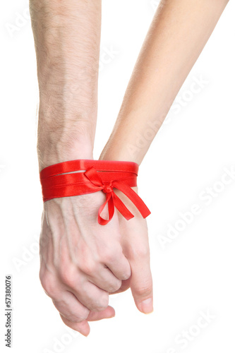 Mans and girls hands tied with ribbon isolated on white