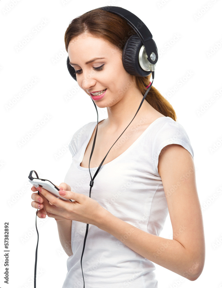 Young woman enjoying music using headphones Young woman enjoying music using headphones