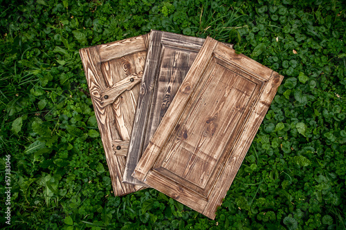 Three wooden doors lying on grass in park photo