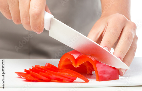 Cook is chopping bell pepper