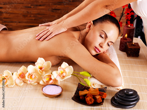 Masseur doing massage on woman body in spa salon