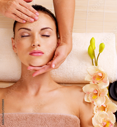 Masażysta robi masaż głowy kobiety w salonie spa