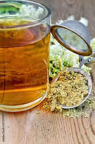 Canvas Print Herbal tea from meadowsweet dry in a strainer with a mug