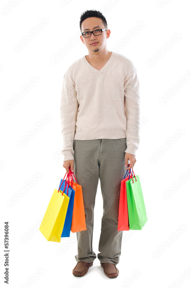 Bored Asian man holding shopping bags Bored Asian man holding shopping bags