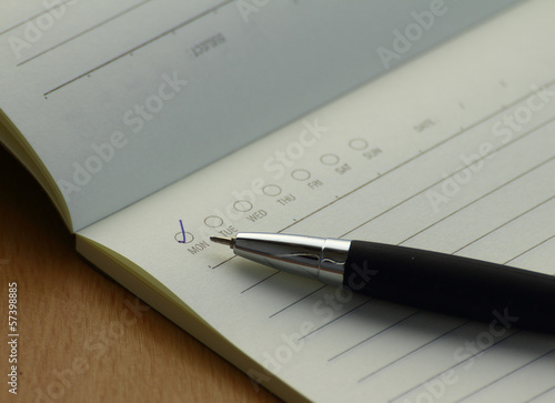 Pen and business plan notebook on wooden desk photo