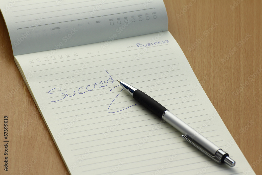 Pen and business plan notebook on wooden desk Pen and business plan notebook on wooden desk
