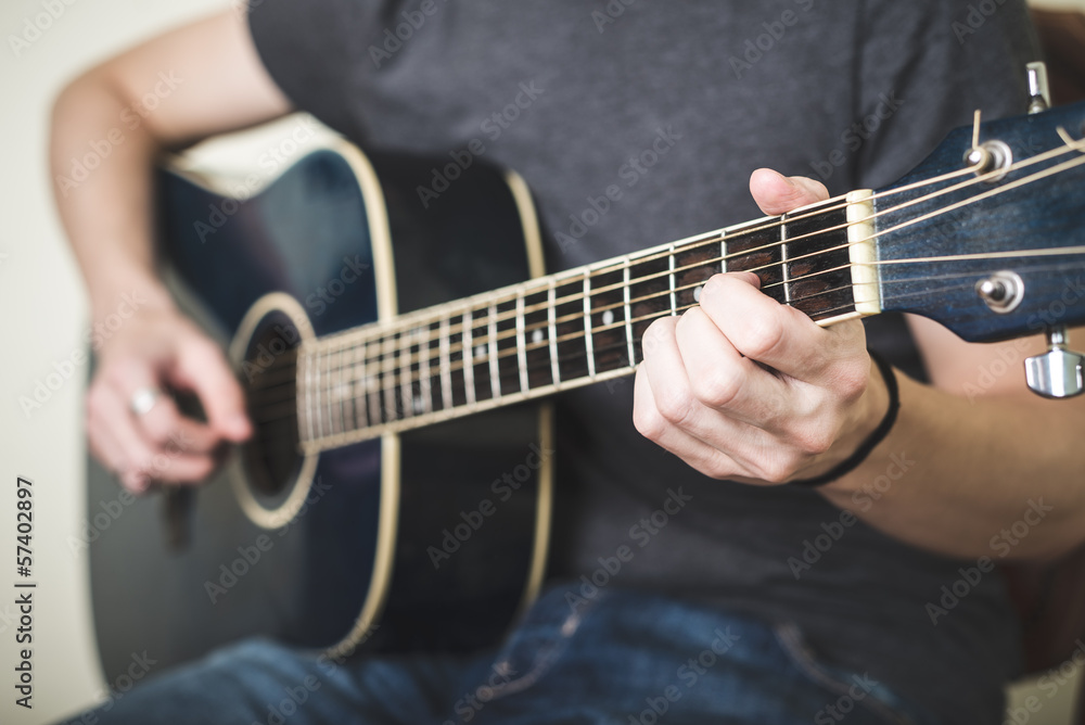 close up of hands playing guitar