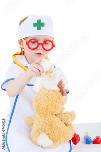 Little girl dressed as nurse and in glasses bandages head to toy photo