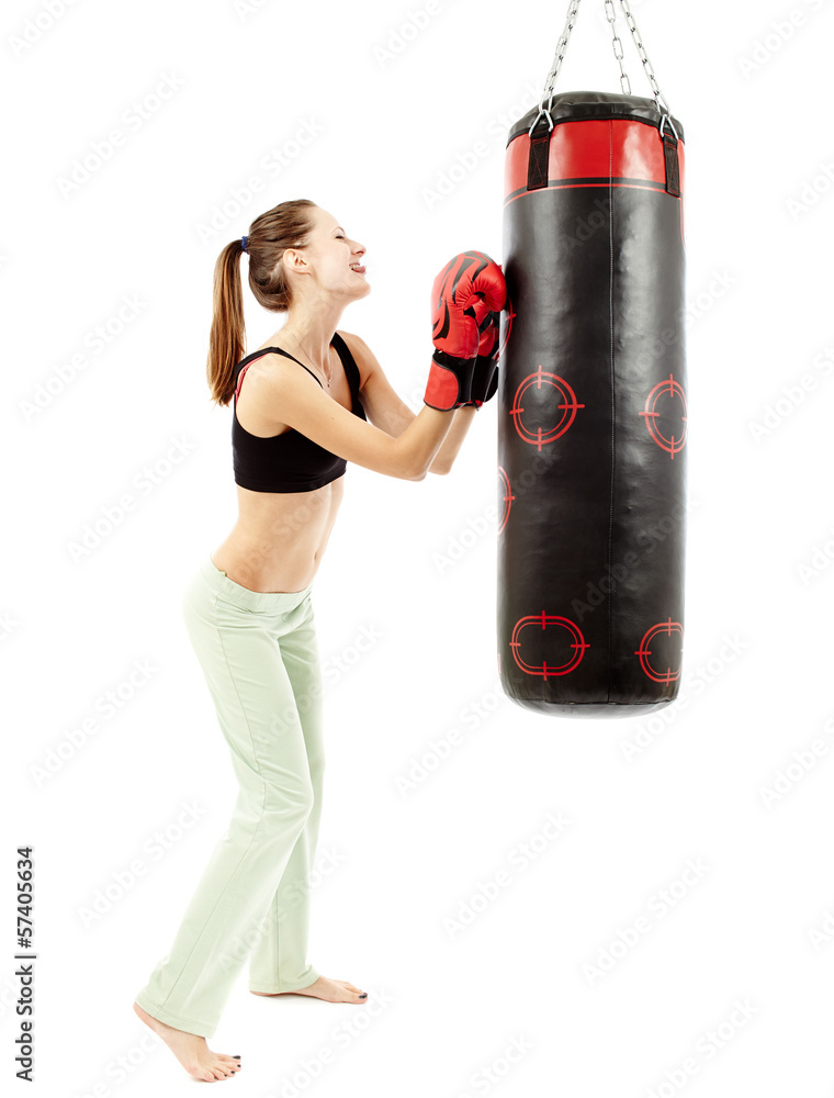 Athletic woman having fun and pulling faces to a punching bag