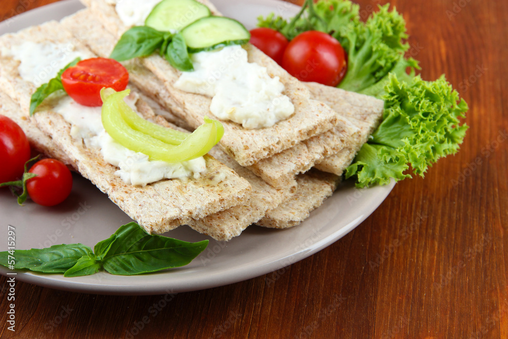 Tasty crispbreads with vegetables on wooden background Tasty crispbreads with vegetables on wooden background