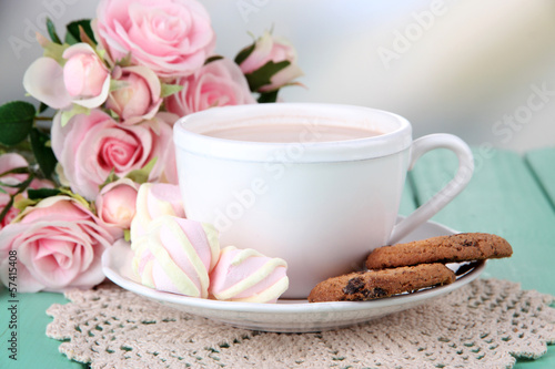 Cocoa drink on wooden table, on bright background