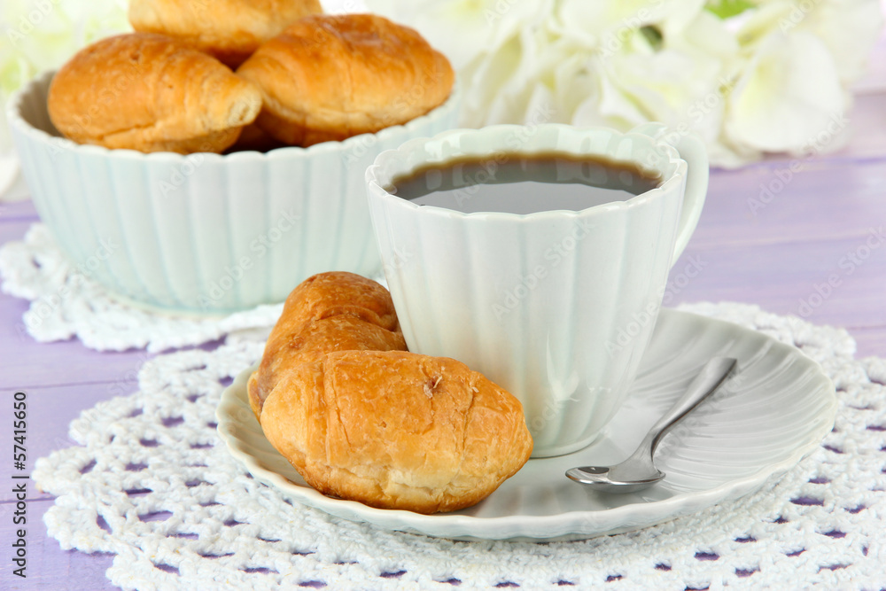 Tasty croissants and cup of coffee on table close-up Tasty croissants and cup of coffee on table close-up