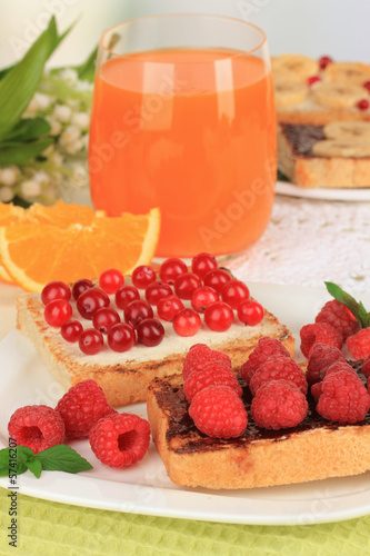 Delicious toast with berries on table on light background