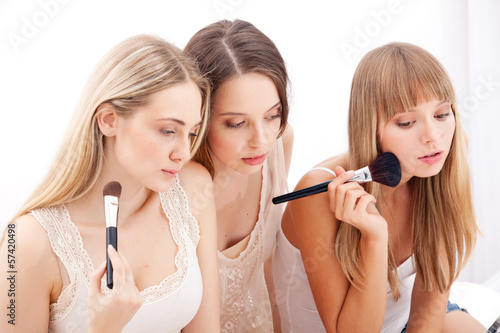 Group of women applying makeup on face